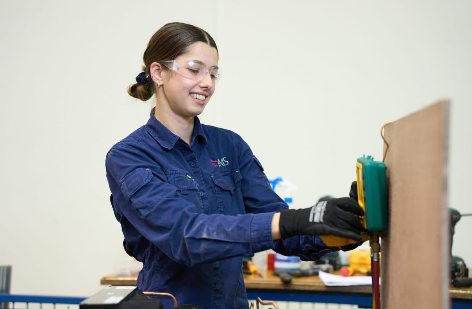 Female apprentice sanding wood.